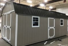 a storage shed with two windows on the roof