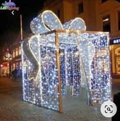 an outdoor display in the middle of a city at night with christmas lights on it