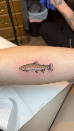 a small fish tattoo on the arm