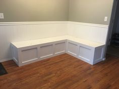 an empty room with white walls and wood flooring