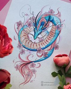 a drawing of a snake on paper next to flowers