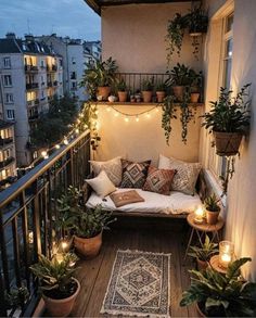 a balcony with potted plants and lights on the balconies is lit up by string lights