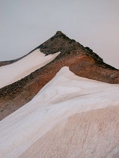 a snowboarder is going down a snowy hill