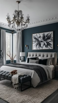 a bedroom with blue walls, white bedding and a chandelier hanging from the ceiling