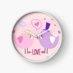 a clock with two birds on it and the words love is written in pink letters