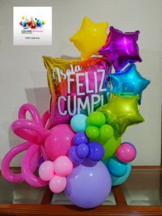 balloons and heliums in a vase with the words feliz cumpi on it