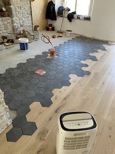 a room that is being remodeled with hard wood flooring and hexagonal tiles