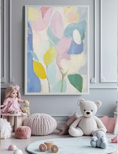 there is a painting on the wall and some stuffed animals in front of it,