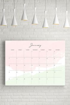 a calendar hanging on a brick wall with white lamps above it and a pink background