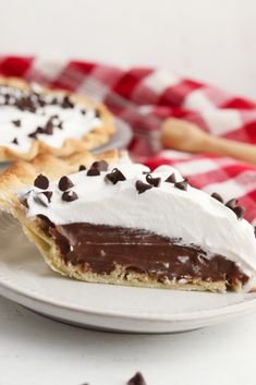 two pies sitting on top of a white plate covered in whipped cream and chocolate