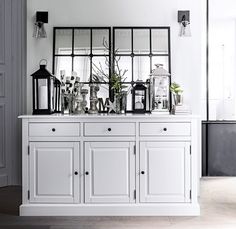 a white dresser with mirrors and vases on it