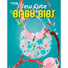 a baby bib is hanging from a tree with flowers on it and the words, new cutie baby bibs