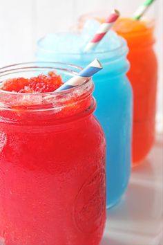 three mason jars filled with different colored drinks