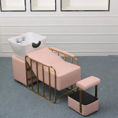 a pink chair with a sink and stool in front of three pictures on the wall