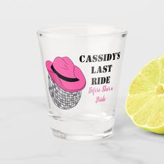 a shot glass with a pink cowboy hat on it next to a lemon slice and the words, caddy's last ride