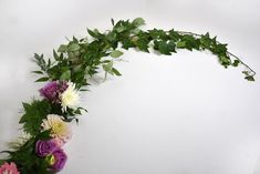 an arrangement of flowers arranged in the shape of a curved frame on a white background