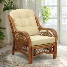 a wicker chair sitting on top of a rug in front of a large window