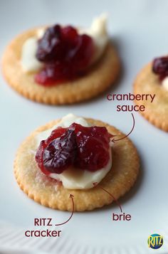 three cranberry sauces on crackers with cream cheese and dried cranberries