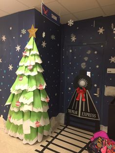 a christmas tree made out of paper in an office cubicle decorated with snowflakes