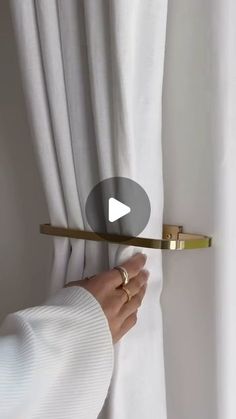 a person is opening the curtain with a gold handle