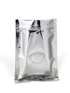 a silver foil bag filled with liquid on top of a white table next to a cup