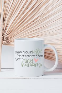 a white coffee mug with the words may your coffee be stronger than tiny humans