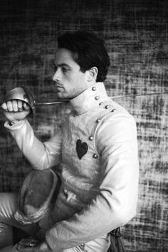 black and white photograph of man in costume holding an apple