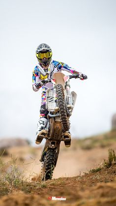 a man riding a dirt bike on top of a dirt field