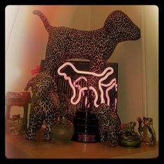 a neon sign that is on top of a shelf next to some animal figurines