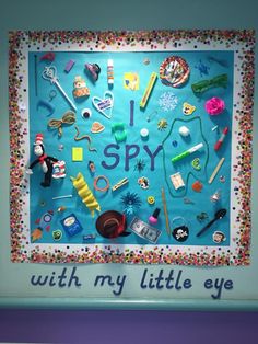 a bulletin board with lots of items on it and the words i spy written in blue