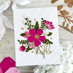 a close up of a greeting card with flowers on it and white ribbon in the background