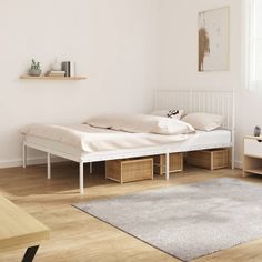 a white bed sitting on top of a wooden floor