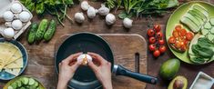 a person is preparing food on a cutting board with vegetables and other foods around them