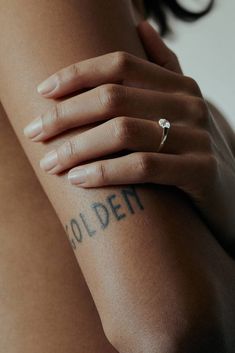 a close up of a person's arm with a tattoo on her left arm