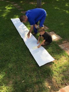 two men working on a large white piece of paper