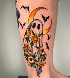 a woman's leg with sunflowers, bats and a ghost on it