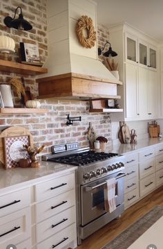 a kitchen with white cabinets and brick wall