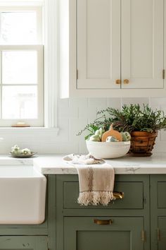 a white sink sitting under a window next to a green counter top in a kitchen