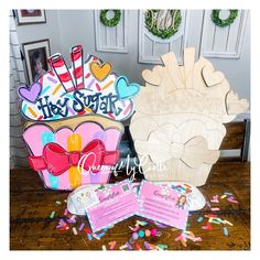 two wooden cut outs with the words happy birthday on them and some confetti sprinkles