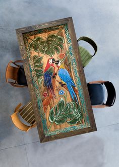 an overhead view of a table with two chairs and a painting on the wall above it