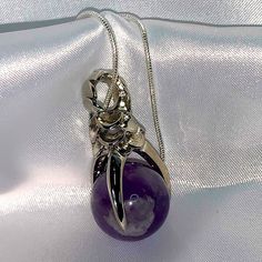 Pendant Made Of Amethyst Ball Held In A Silver Dragon Claw, Hanging In A Snake Silver Chain With Lobster Clasp. Mystical Silver Amethyst Necklaces, Mystical Silver Amethyst Crystal Necklace, Silver Amethyst Pendant Crystal Necklace, Silver Amethyst Healing Jewelry, Silver Amethyst Jewelry For Healing, Silver Amethyst Necklace For Healing, Silver Amethyst Birthstone Crystal Necklace, Silver Crystal Birthstone Necklace, Silver Amethyst Round Pendant Crystal Necklaces