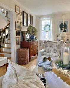 a living room filled with furniture and lots of pictures on the wall next to stairs