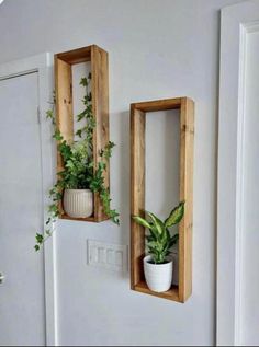 two wooden boxes with plants in them on the wall