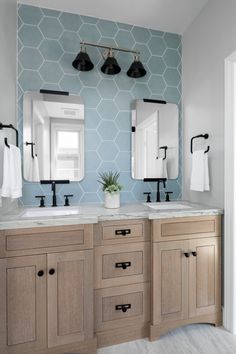 a bathroom with two sinks and three mirrors