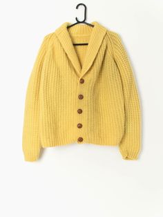 50s hand knitted cardigan in yellow chunky knit wool. A wonderfully rare 1950s vintage mens cardigan in bright yellow with large, brown real leather buttons. This chunky knit cardigan features stretchy cuffs, a chunky, stretchy neck and a stretchy hemline for the most personal fit. Made from a slightly coarse, heavy weight wool; this hand knitted cardigan is a super snug! Originally made for men but this cardigan can be worn and enjoyed by everyone! Our recommended size (mens): Small to medium O Yellow Sweater With Button Closure For Winter, Classic Yellow Winter Cardigan, Yellow Knitted Winter Cardigan, Yellow Buttoned Sweater For Fall, Fall Yellow Sweater With Buttons, Vintage Mustard Sweater For Winter, Small Wardrobe, Vintage Windbreaker, Mens Cardigan