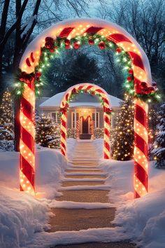 an archway decorated with christmas lights and candy canes in front of a white house