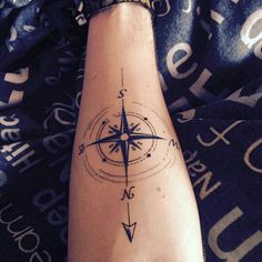 a person's foot with a compass tattoo on it