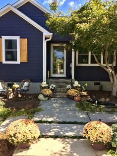 a blue house with white trim and wooden shutters on the front door is shown