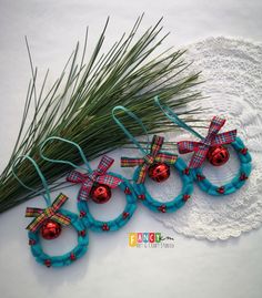 four christmas ornaments are sitting on a doily next to some pine needles and grass