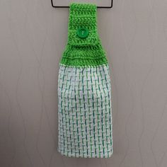 a green and white towel hanging on a hook